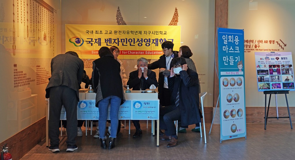 자원봉사에 나선 벤자인인성영재학교 학생들이 관광객들에게 일회용 마스크 제작법을 설명하고 있다