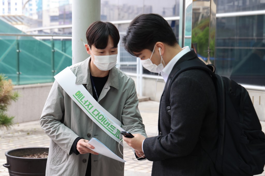 사진2. 한수원 홍보지원단 직원이 시민에게 에너지 절약 실천요령 리플렛을 나눠주고 있다