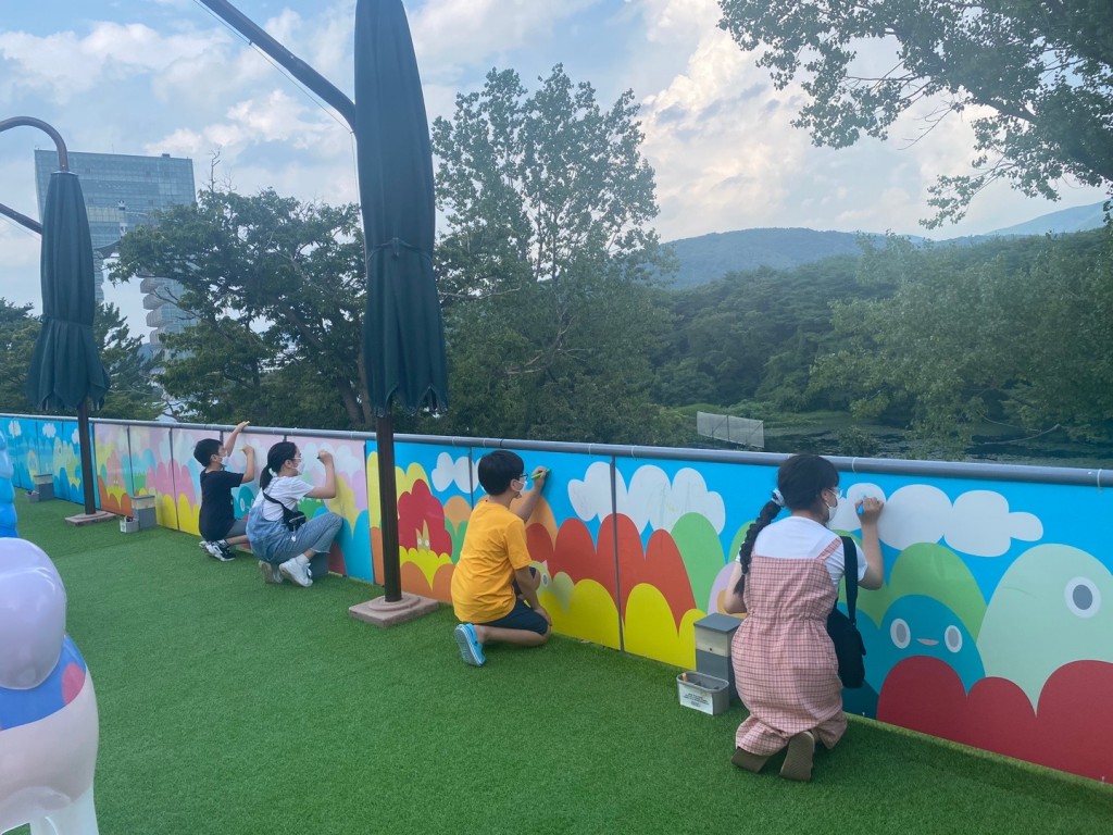 지난해 홍지민작가 전시때 진행된 드로잉 프로그램에 참여한 아동들이 아트 월에 그림을 그리는 모습